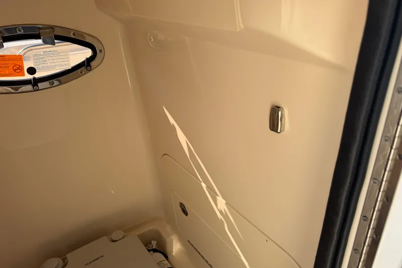 Slide: The Image of 2024 Grady-White Fisherman 236 interior cabin with porthole and storage compartment. - 28