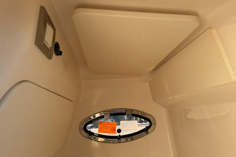 Slide: The Image of 2024 Grady-White Fisherman 236 interior cabin with oval window and control panel. - 29