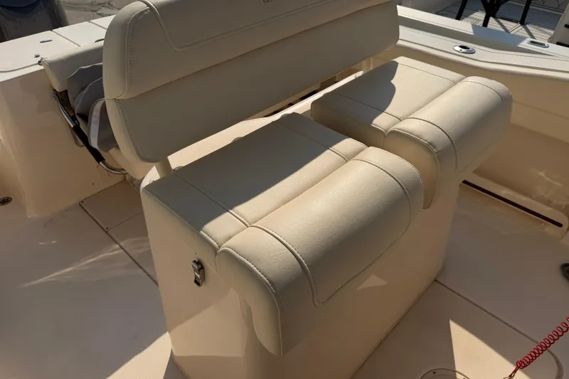 Slide: The Image of 2024 Grady-White Fisherman 236 boat seating, featuring beige cushioned seats in sunlight. - 34