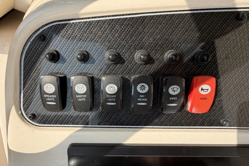 Slide: The Image of Control panel of 2024 Grady-White Fisherman 236 with labeled switches for lights and horn. - 41