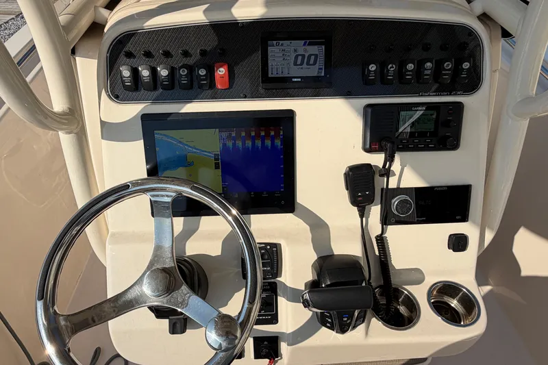 Slide: The Image of 2024 Grady-White Fisherman 236 helm with steering wheel, navigation, and communication controls. - 47