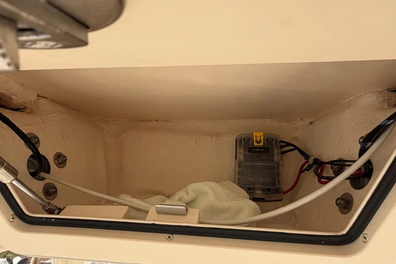 Slide: The Image of 2024 Grady-White Fisherman 236 boat compartment with wiring and a 12-volt DC box. - 49