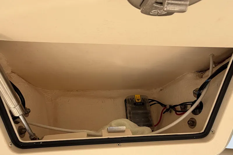 Slide: The Image of 2024 Grady-White Fisherman 236 storage compartment with wiring and hydraulic components. - 50