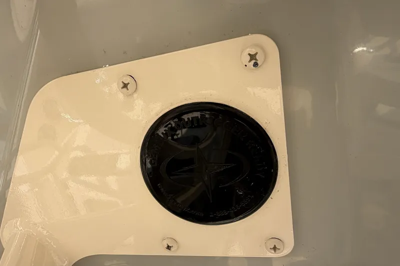 Slide: The Image of 2024 Grady-White Fisherman 236 boat detail with black circular emblem and screws. - 54