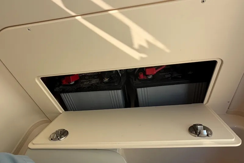 Slide: The Image of 2024 Grady-White Fisherman 236 boat battery compartment with dual batteries visible. - 56