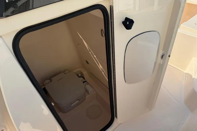 Slide: The Image of 2024 Grady-White Fisherman 236 boat interior with compact marine toilet. - 61