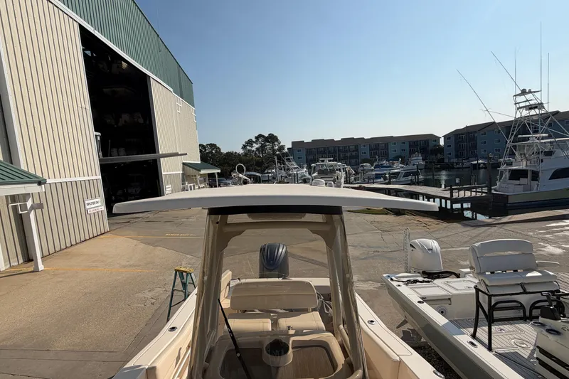 Slide: The Image of 2024 Grady-White Fisherman 236 boat docked at a marina with surrounding buildings. - 68