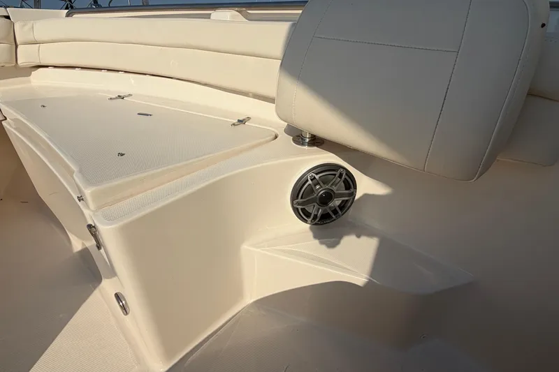 Slide: The Image of 2024 Grady-White Fisherman 236 boat interior with cushioned seating and speaker detail. - 77
