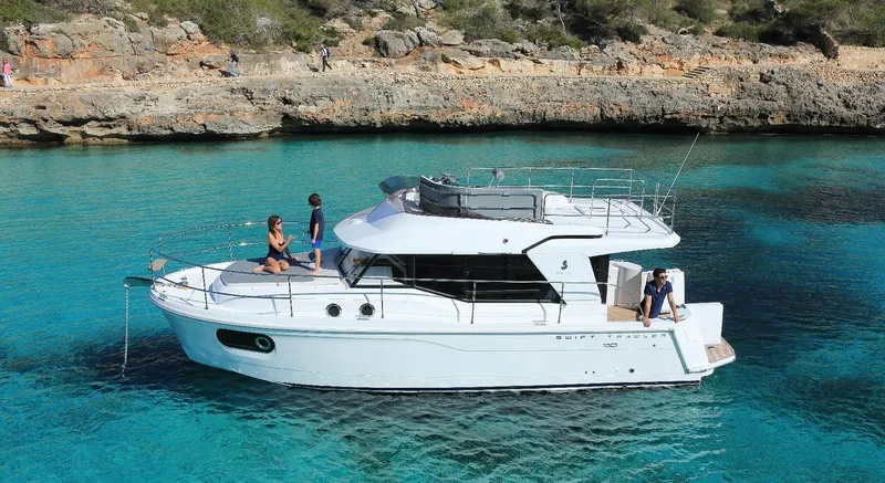 Slide: The Image of Manufacturer Provided Image: 2020 Beneteau Swift Trawler 30 anchored in clear blue water with people relaxing. - 16