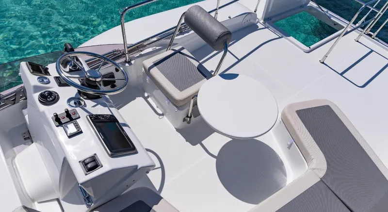 Slide: The Image of Manufacturer Provided Image: 2020 Beneteau Swift Trawler 30 anchored in clear blue water near a forested shoreline. - 18