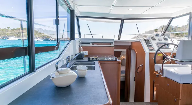 Slide: The Image of Manufacturer Provided Image: 2020 Beneteau Swift Trawler 30 in clear turquoise waters near a rocky shoreline. - 24