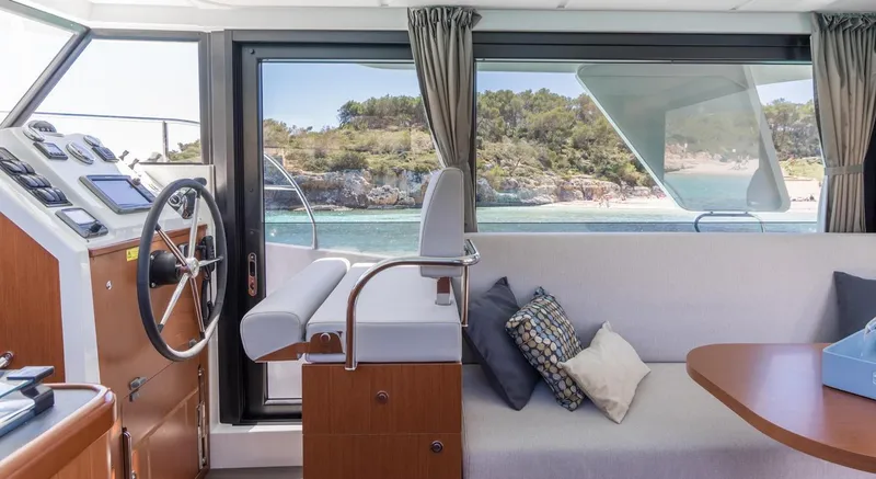 Slide: The Image of Manufacturer Provided Image: Interior of 2020 Beneteau Swift Trawler 30, featuring helm, seating, and scenic window view. - 34