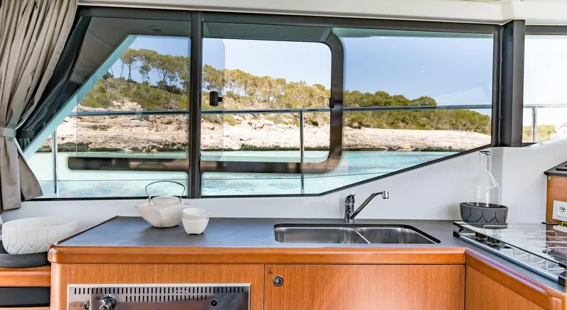 Slide: The Image of Manufacturer Provided Image: Interior view of 2020 Beneteau Swift Trawler 30, featuring a modern kitchen and scenic window view. - 35
