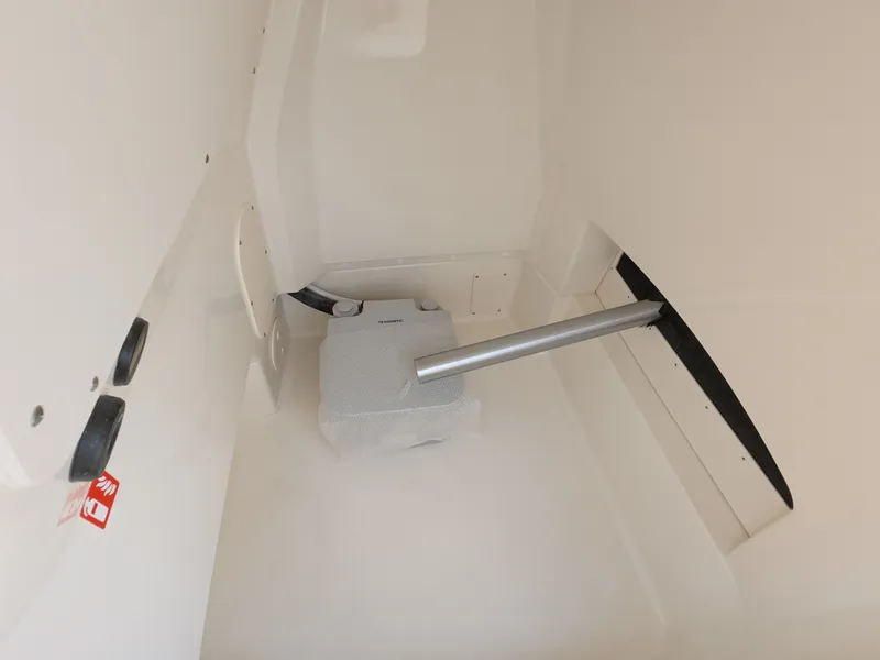 Slide: The Image of Interior of a 2027 Boston Whaler 220 Dauntless with storage space and a support bar. - 16