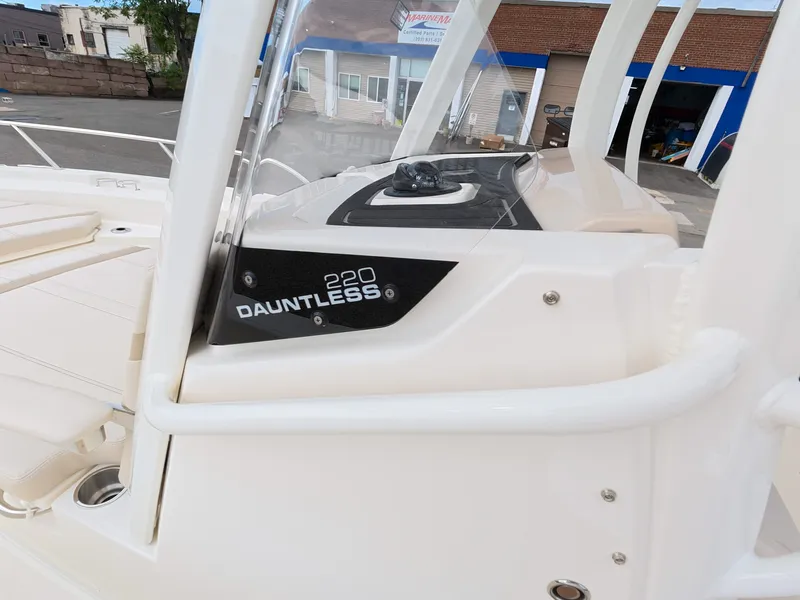 Slide: The Image of The image shows the starboard side of the Boston Whaler 220 Dauntless with sleek lines and modern details. - 13