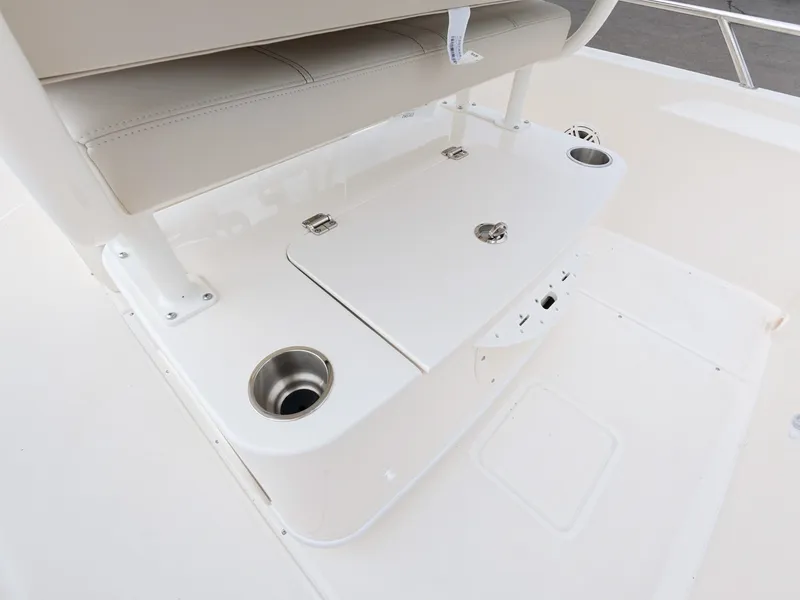 Slide: The Image of The image shows the seating area of a Boston Whaler 220 Dauntless with cup holders and storage. - 10