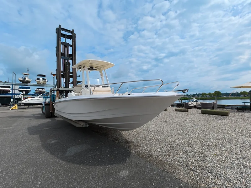 Slide: The Image of A 2027 Boston Whaler 220 Dauntless on a boat lift in a marina area. - 2