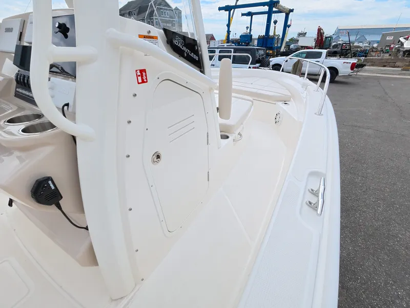 Slide: The Image of The image shows the deck of a 2027 Boston Whaler 220 Dauntless in a harbor. - 14