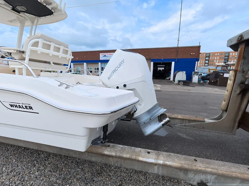Slide: The Image of A 2027 Boston Whaler 220 Dauntless with a Mercury outboard motor, parked on a trailer. - 4