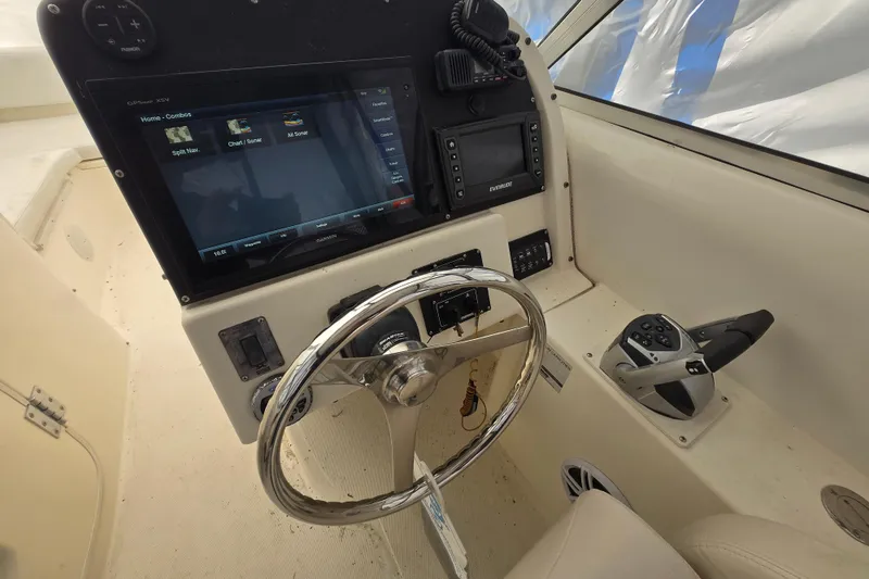 Slide: The Image of 2005 World Cat 250 DC boat dashboard with steering wheel and navigation controls. - 10