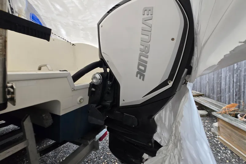 Slide: The Image of 2005 World Cat 250 DC boat with Evinrude outboard motor, partially covered. - 13