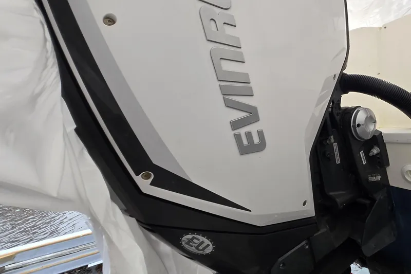 Slide: The Image of Evinrude outboard motor on a 2005 World Cat 250 DC boat, partially covered. - 14