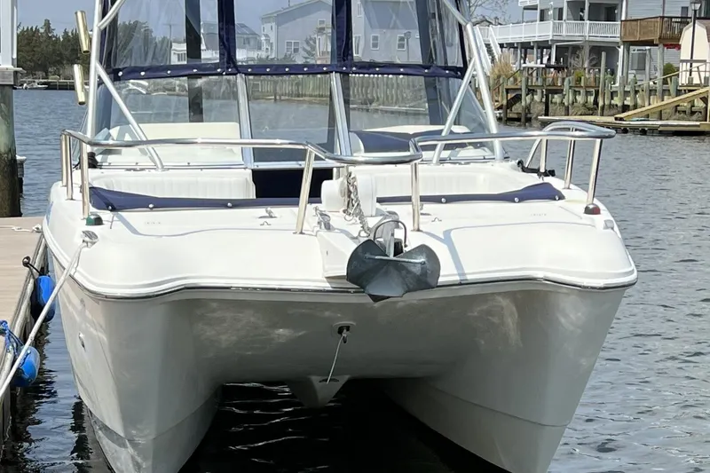 Slide: The Image of 2005 World Cat 250 DC boat docked at marina, featuring sleek design and spacious deck. - 17