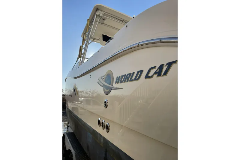 Slide: The Image of 2005 World Cat 250 DC boat side view with logo under clear blue sky. - 18