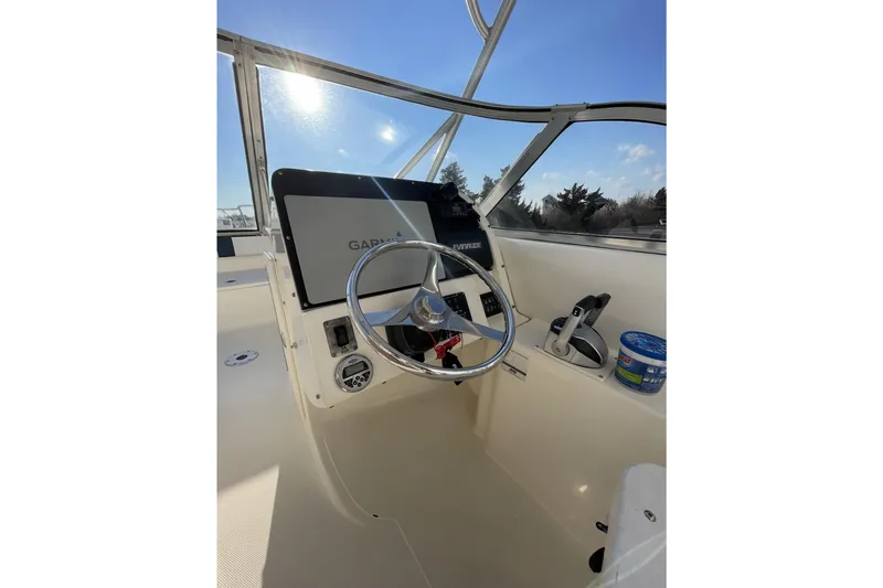 Slide: The Image of 2005 World Cat 250 DC boat helm with steering wheel and navigation equipment. - 19