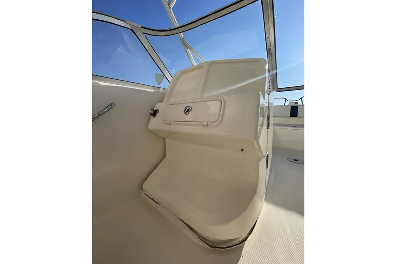 Slide: The Image of 2005 World Cat 250 DC boat interior with white seating and clear windshield. - 21
