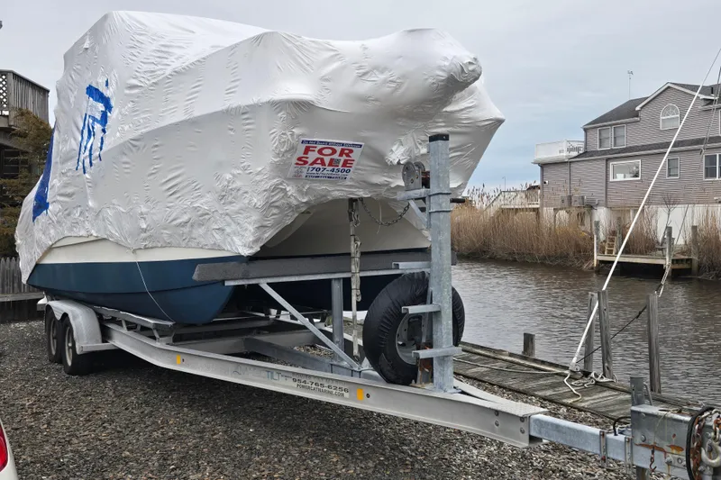 Slide: The Image of Covered 2005 World Cat 250 DC boat on trailer, for sale by waterfront property. - 5
