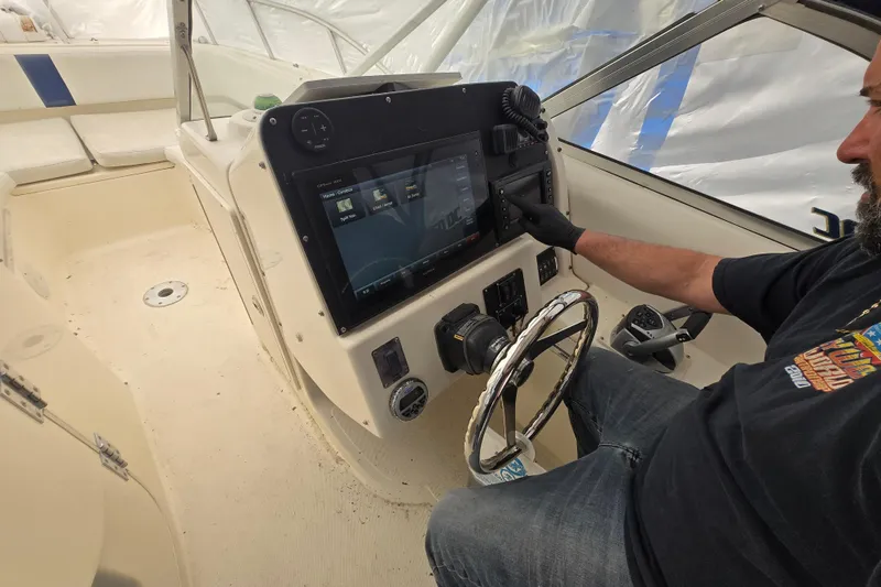 Slide: The Image of Man operating the control panel of a 2005 World Cat 250 DC boat. - 9