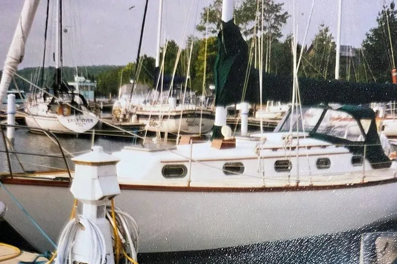 Slide: The Image of 1980 Cape Dory 33 sailboat docked at a marina with other boats. - 2
