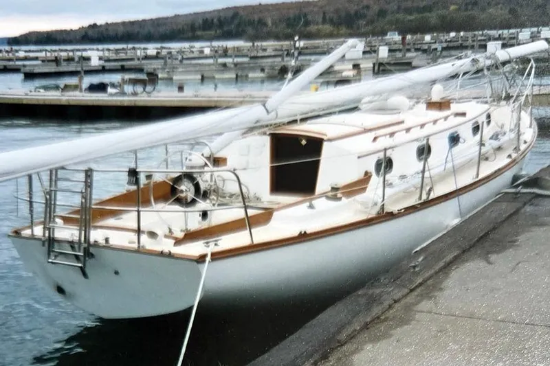 Slide: The Image of 1980 Cape Dory 33 sailboat docked at a marina, showcasing classic design and craftsmanship. - 3