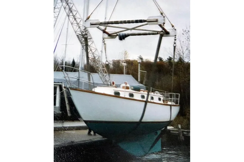 Slide: The Image of 1980 Cape Dory 33 sailboat being lifted by a crane at a marina. - 6