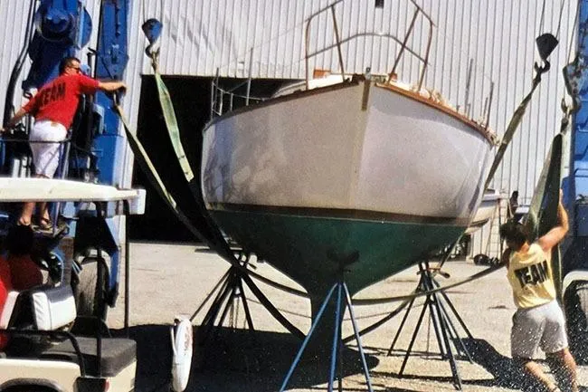 Slide: The Image of 1980 Cape Dory 33 sailboat being lifted by a team at a marina. - 7