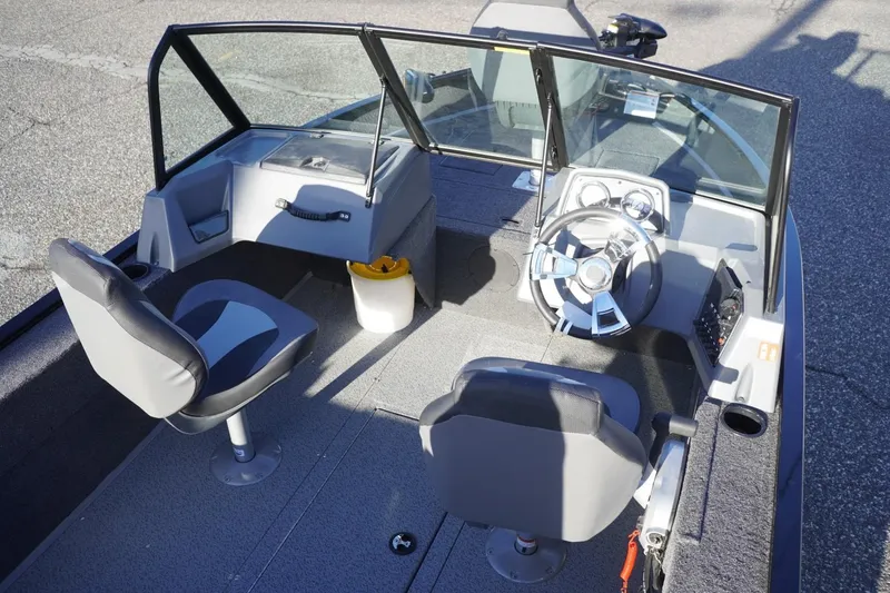 Slide: The Image of 2026 Lowe Fishing Machine 1625WT interior with steering wheel and seating. - 11