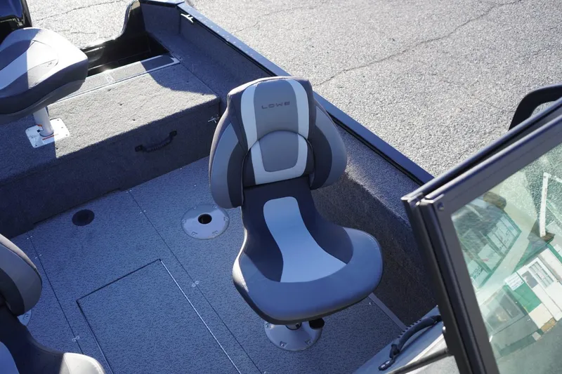 Slide: The Image of 2026 Lowe Fishing Machine 1625WT boat interior with cushioned seating and carpeted flooring. - 14