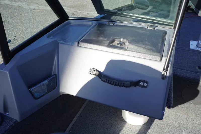 Slide: The Image of 2026 Lowe Fishing Machine 1625WT interior dashboard with storage compartment and handle. - 18