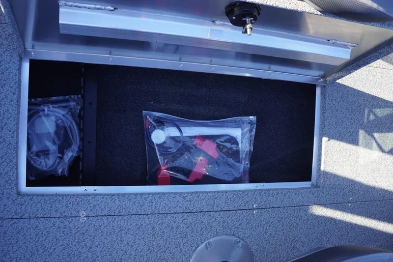 Slide: The Image of Storage compartment of 2026 Lowe Fishing Machine 1625WT with accessories in plastic bags. - 21