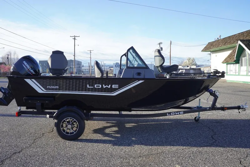 Slide: The Image of 2026 Lowe Fishing Machine 1625WT boat on trailer, parked outdoors. - 5