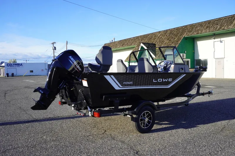 Slide: The Image of 2026 Lowe Fishing Machine 1625WT boat on trailer, parked outdoors. - 6