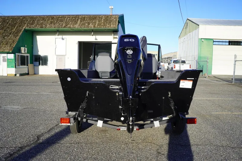 Slide: The Image of 2026 Lowe Fishing Machine 1625WT boat with outboard motor, parked outdoors. - 8