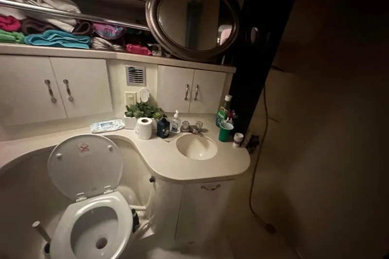 Slide: The Image of Bathroom interior of 1996 Mainship 40 Sedan Bridge with sink, toilet, and storage cabinets. - 10