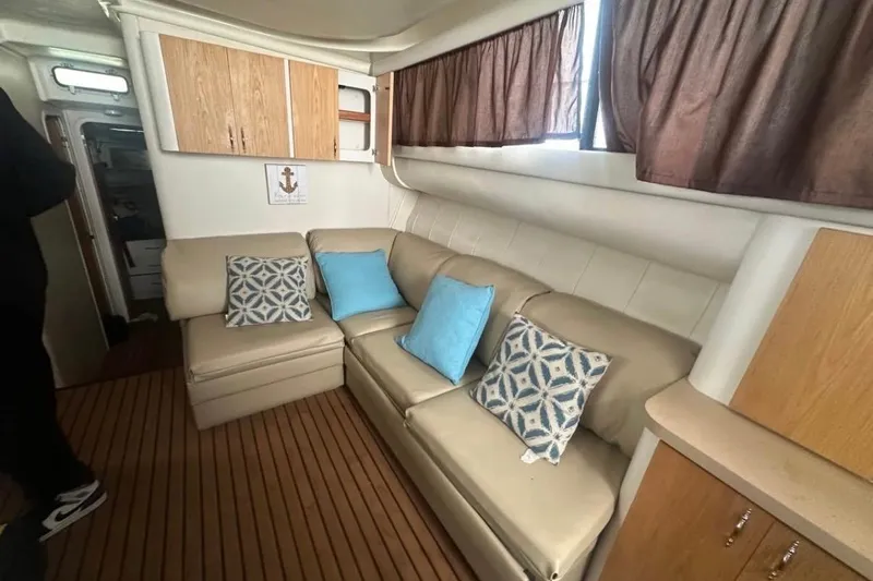 Slide: The Image of Interior of 1996 Mainship 40 Sedan Bridge with beige seating and decorative pillows. - 9