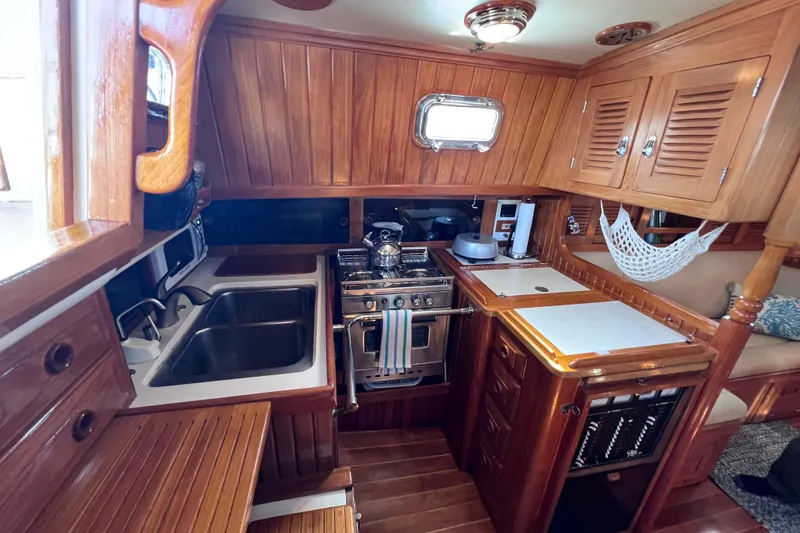 Slide: The Image of Cozy 1990 Cabo Rico 38R yacht kitchen with wooden cabinetry and modern appliances. - 10