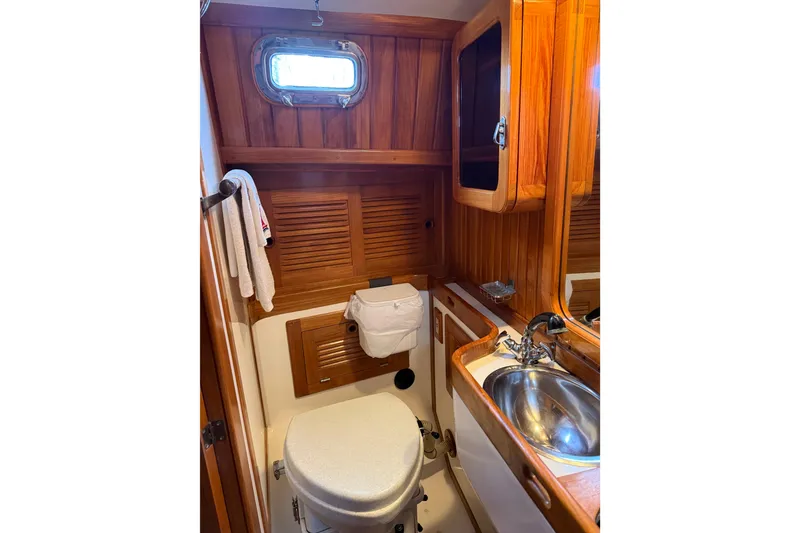 Slide: The Image of 1990 Cabo Rico 38R yacht bathroom with wooden cabinetry and stainless steel sink. - 11