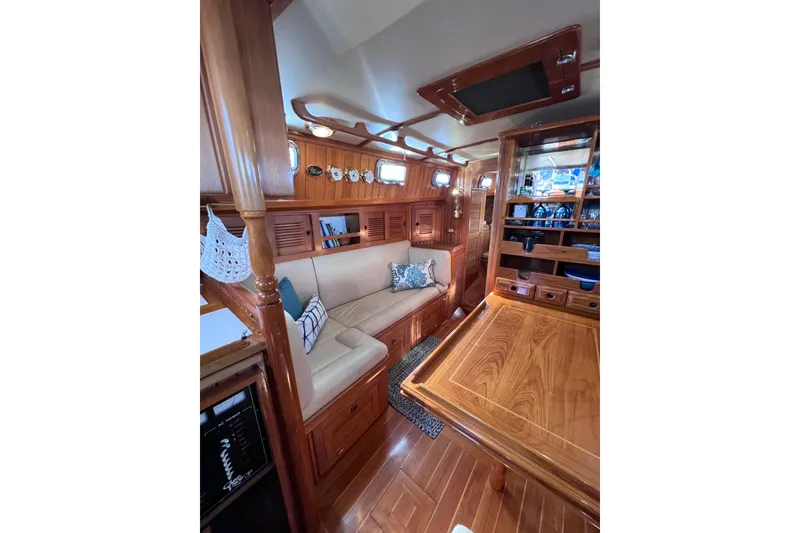 Slide: The Image of Luxurious 1990 Cabo Rico 38R yacht interior with elegant wood finish and cozy seating area. - 12