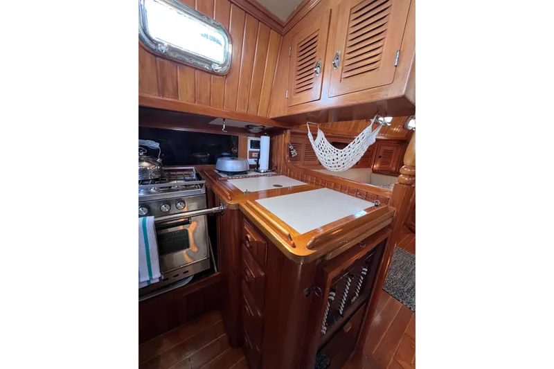 Slide: The Image of Cozy 1990 Cabo Rico 38R yacht galley with wooden cabinetry and compact stove. - 15