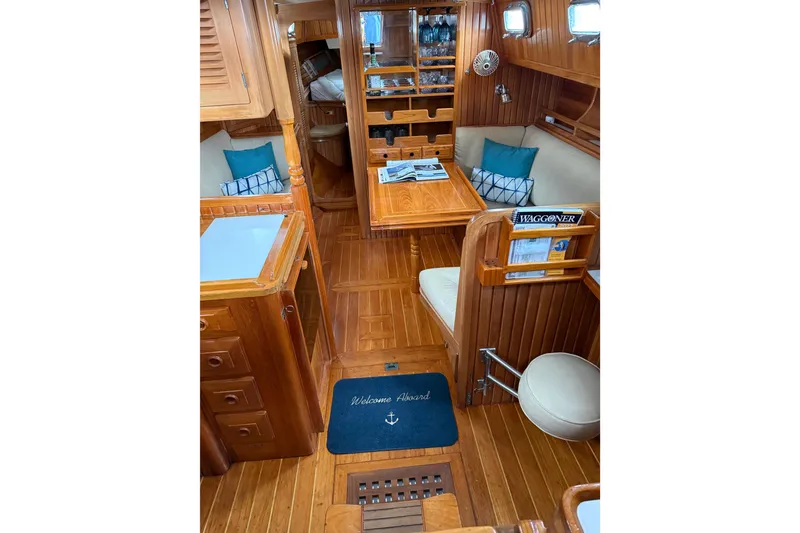 Slide: The Image of Interior of 1990 Cabo Rico 38R sailboat with wooden furnishings and cozy seating area. - 2